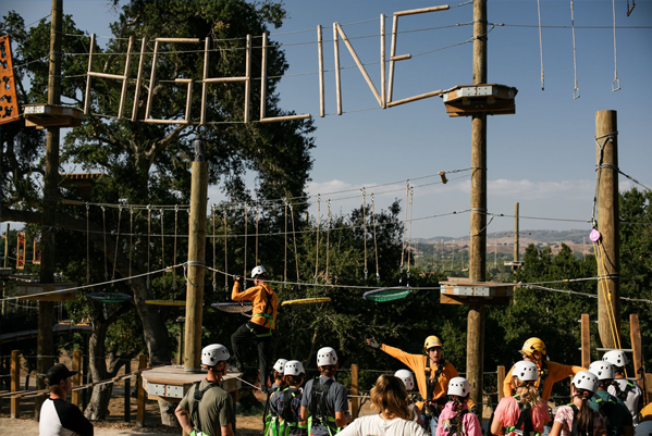 A guest crossing a treetop element on the Highline Adventures adventure course near Solvang