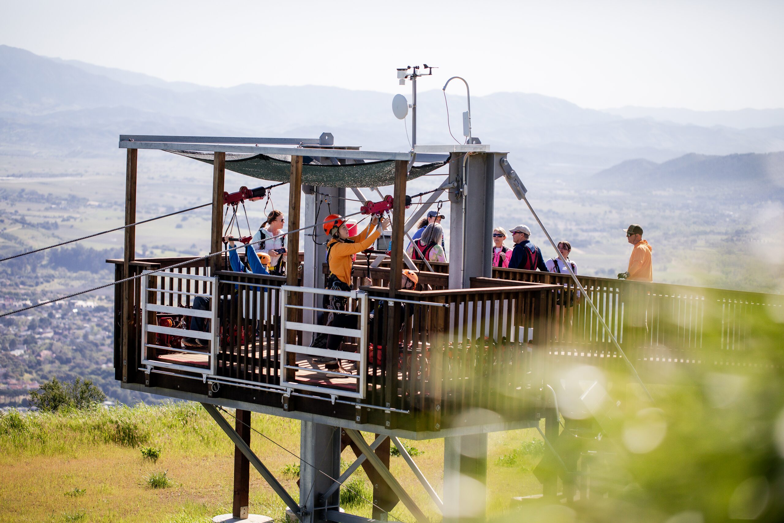 Group of guests on the arrival platform tower at the end of a Highline Adventures zipline