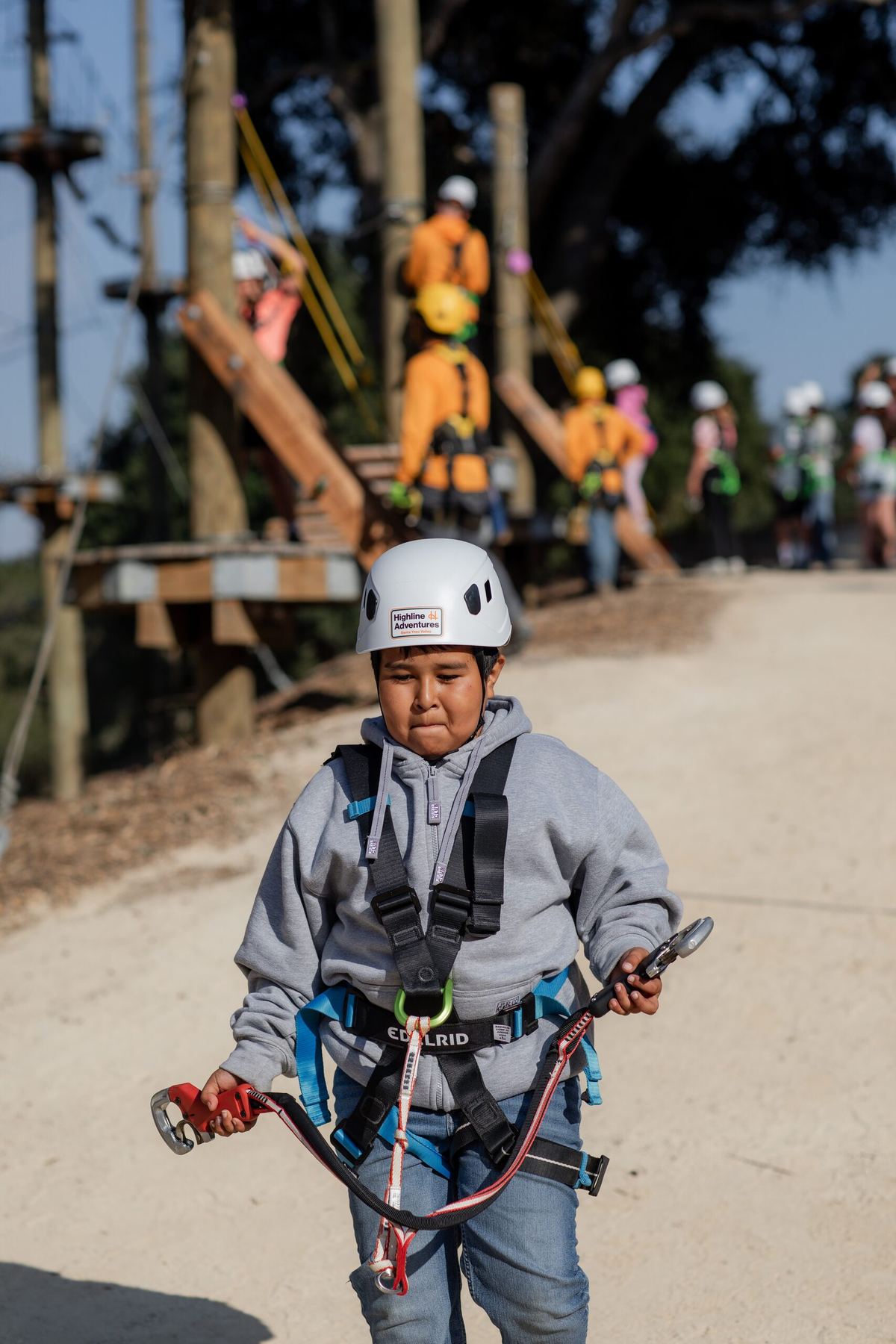 A young student in a helmet and harness, ready for the Adventure Park.
