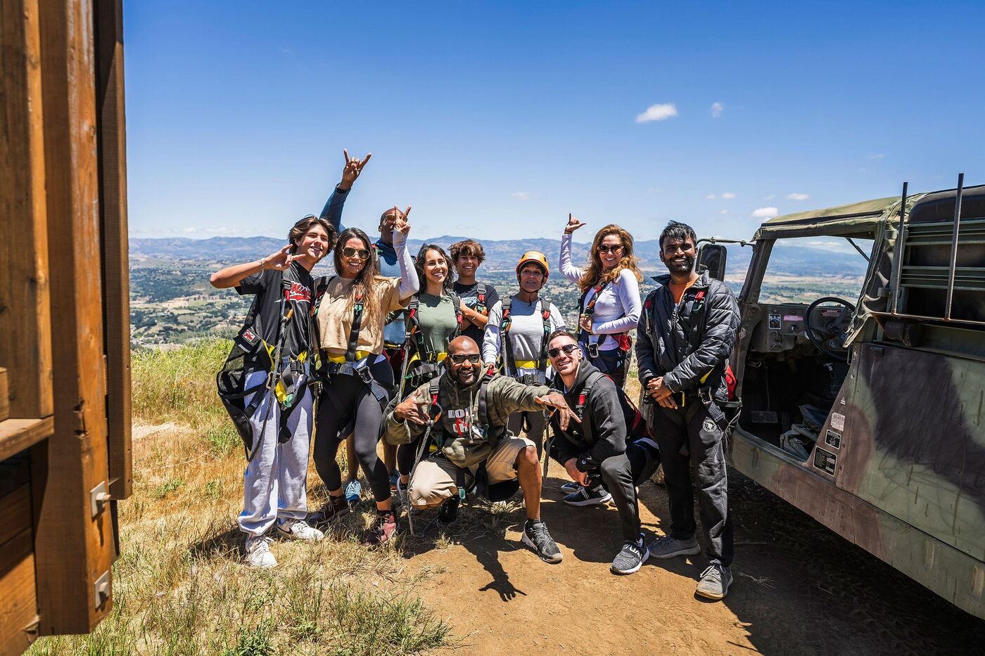 A birthday group celebrating at the summit beside the 4x4 vehicle before their zipline tour at Highline Adventures.