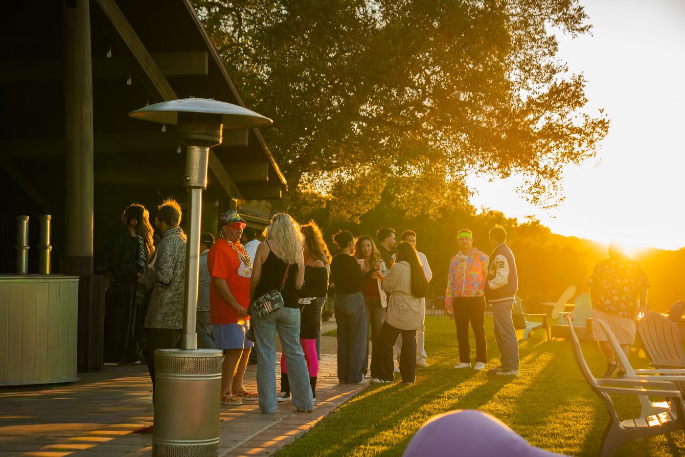 A group of friends celebrating a milestone birthday at golden hour on a hilltop patio overlooking the Santa Ynez Valley.